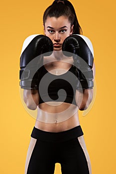 Sportsman, woman boxer fighting in gloves. on yellow background. Boxing and fitness concept.