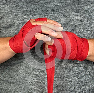 sportsmanâ€™s hands wrapped in a red elastic sports bandage