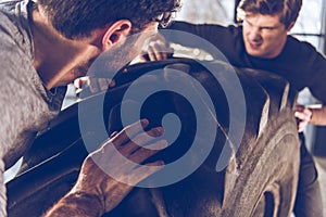 Sportsmen exercising with big tire at gym workout