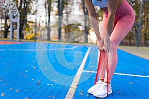 Sportswoman doing exercises with fitness resistance band.