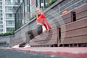 Sportswoman doing leg stretching exercise with medicine ball. Fit woman exercising with ball in gym workout