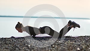 Sportswoman doing push ups standing on knees at beach natural landscape. Wide shot on RED camera