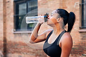 sportswoman drinking water during a workout