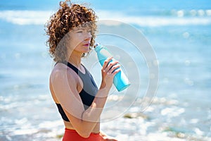 Sportswoman drinking water after workout