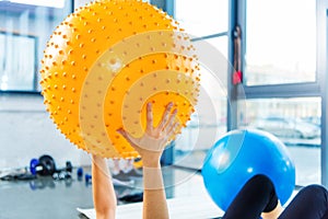 Sportswoman exercising with fitness ball in gym