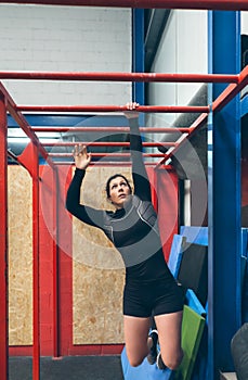 Sportswoman exercising on monkey bars