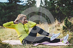 Sportswoman isolaition in nature, Smile fitness girl exercising outdoors in park, activity yoga pose with stretch legs, sporty