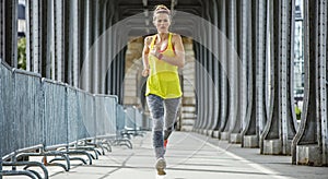 Sportswoman jogging on Pont de Bir-Hakeim bridge in Paris