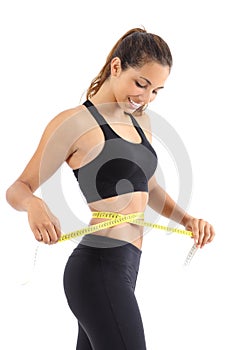 Sportswoman measuring her waist with a measure tape