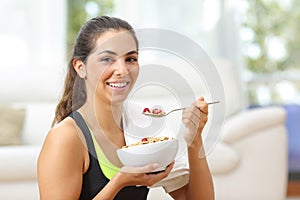 Sportswoman posing with cereals after sport at home