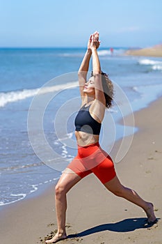 Sportswoman practicing yoga on beach