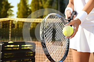 Sportswoman preparing to serve tennis ball at court, closeup