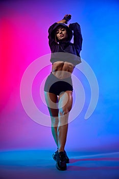 Sportswoman with raised hands posing in studio.