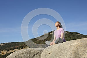 Sportswoman relaxing resting in the top of a cliff