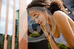 Sportswoman resting while working out outdoors at street