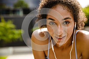 Sportswoman resting while working out outdoors at street