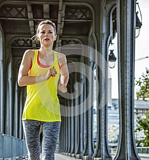 Sportswoman running on Pont de Bir-Hakeim bridge in Paris
