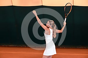 Sportswoman at the tennis court with racquet.