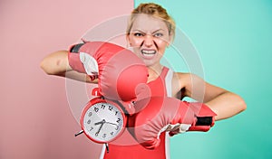 Sportswoman. win the day. angry woman boxing gloves. girl boxer hold alarm clock. morning energy. full of power