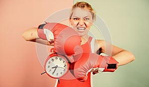 Sportswoman. win the day. angry woman boxing gloves. girl boxer hold alarm clock. morning energy. full of power