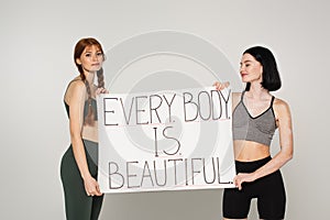 Sportswomen with vitiligo and freckles holding