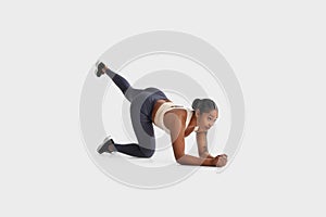 Sporty African American Woman Performing Exercise on White Background