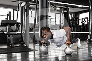Sporty african man doing push-up in a gym.