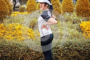 Sporty asian female suffering from pain in waist  injury after sport exercise running jogging and workout at park outdoor