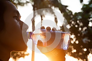 Sporty Asian man drinking water from bottle. Sport and Healthy