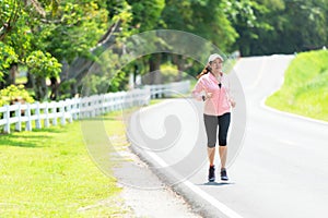 Sporty asian woman runner running and jogging through the road.