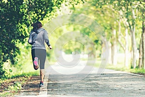 Sporty asian woman runner running and jogging through the road.  Outdoor Workout in a Park