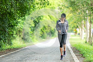 Sporty asian woman runner running and jogging through the road.