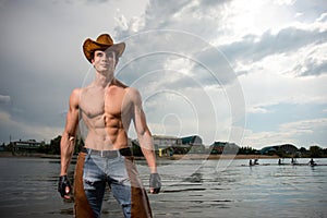 Sporty, athletic, muscular man in a cowboy outfit