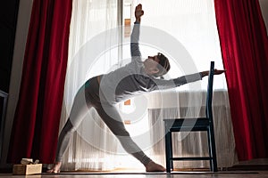Sporty attractive young woman doing side bend, Trikonasana posture