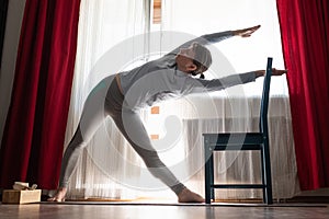 Sporty attractive young woman doing side bend, Trikonasana posture