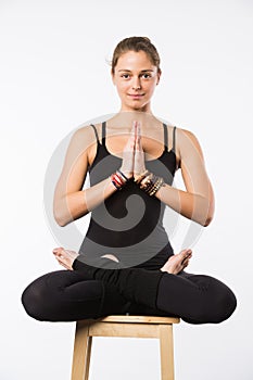 Sporty beautiful young woman sitting in Gomukhasana, Cowface pose, yin yoga Shoelace posture, asana for stretching hips