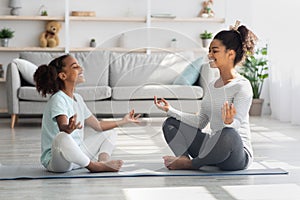 Sporty black family mother and daughter meditating at home