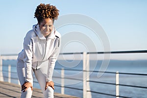 Sporty Black Female Taking Break While Training Outdoors Near Sea