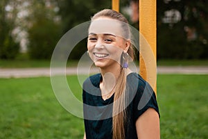 Sporty blonde girl smiling in frame, near the football goal