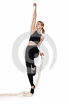Sporty blonde woman in sportswear with rope