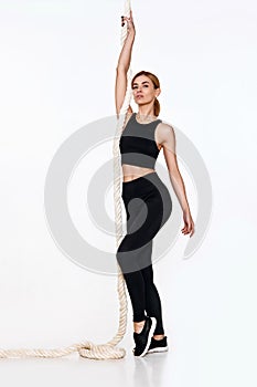 Sporty blonde woman in sportswear with rope