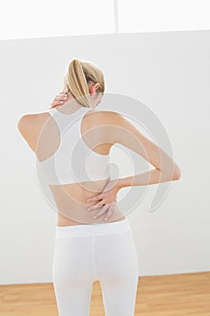 Sporty blonde woman touching her injured nape