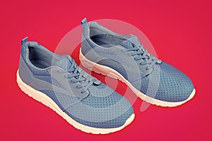 sporty blue sneakers pair on pink background, sport fashion