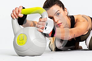 Sporty Caucasian woman doing workout with kettlebell. Image