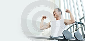 Sporty confident Elderly male in white sportswear smiling while workout. Strong powerful Asian senior man showing biceps and huge