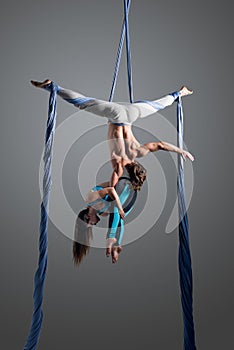 Sporty couple doing exercise with elastics, aerial silk