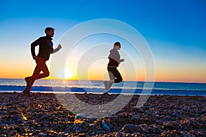 Sporty Couple doing Morning Jogging on Sea Beach at Sunrise