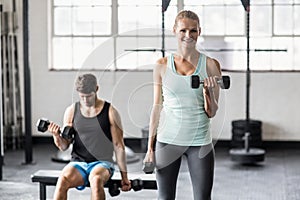 Sporty couple exercising with dumbbells