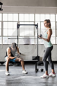 Sporty couple exercising with dumbbells