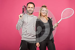 sporty couple holding tennis rackets, isolated